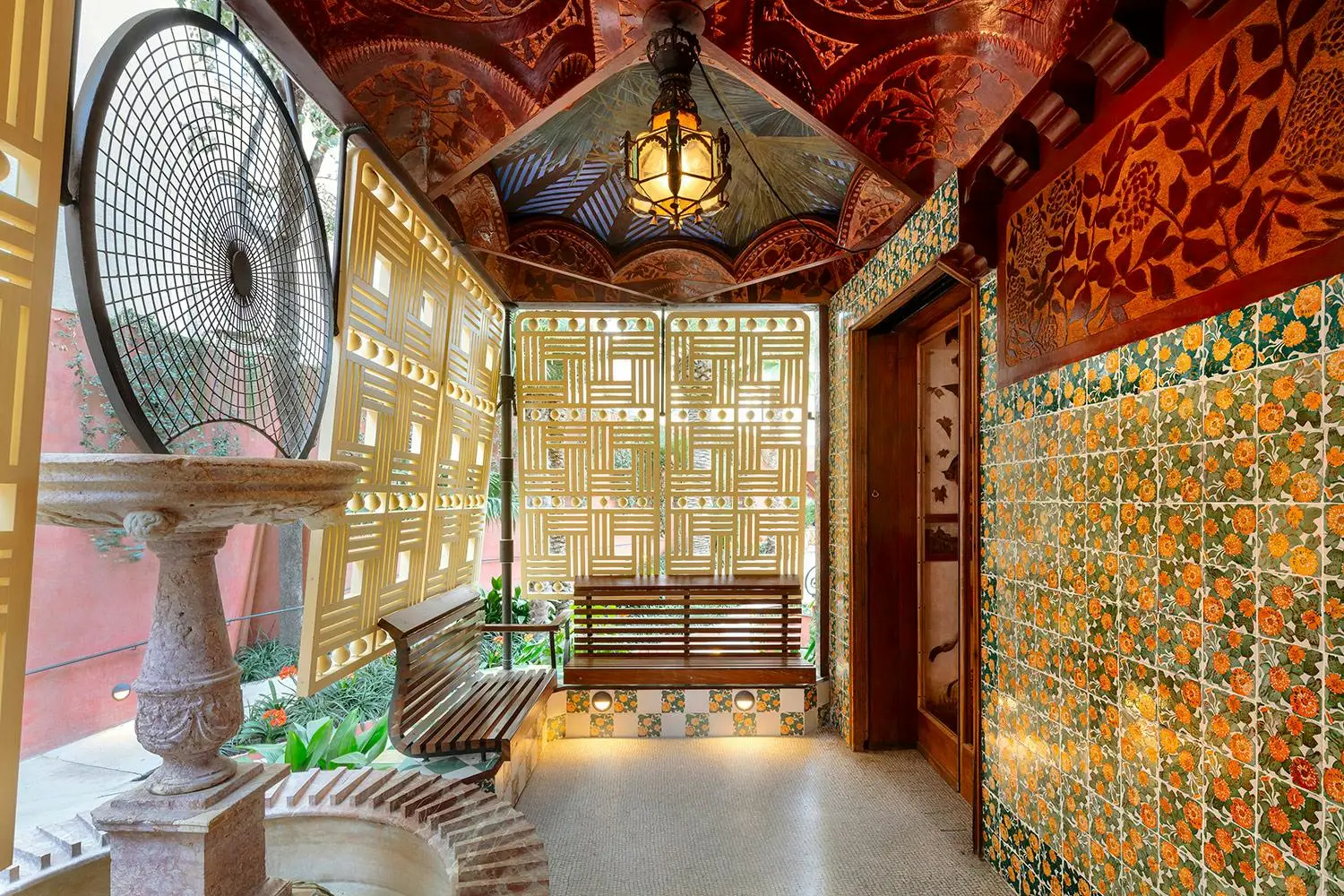 Ornate indoor patio featuring benches, a fountain, and decorative tiles.